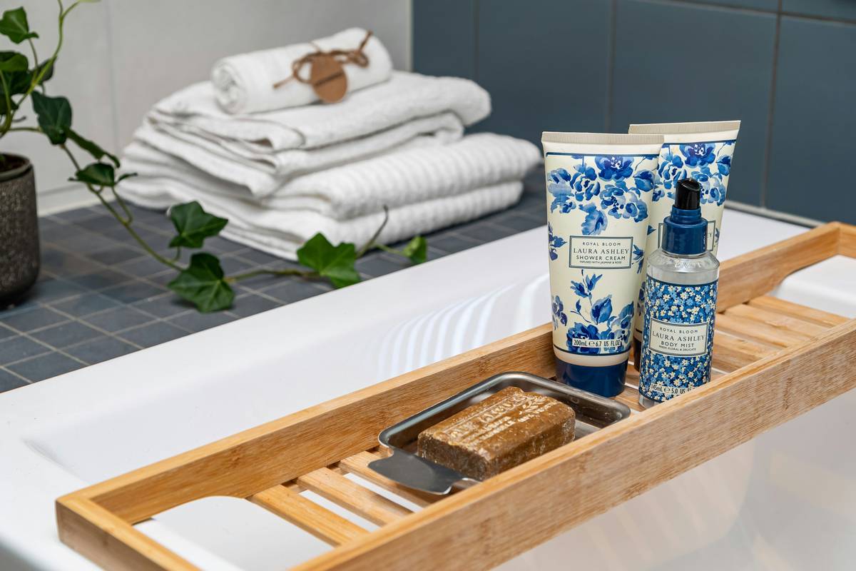 Woman relaxing in a bubble bath with visible suds; bath essential bubble is skincare good question illustrated by irritated skin on arm